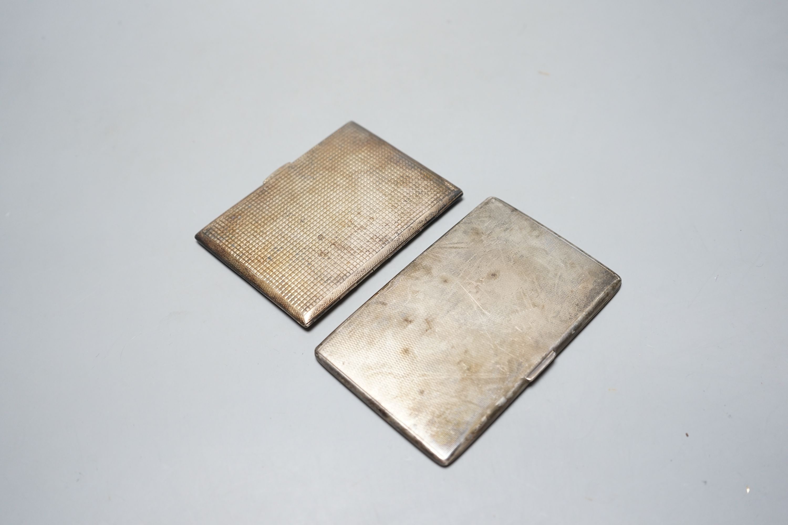 Two 20th century silver cigarette cases, including engine turned, largest, 12.8cm